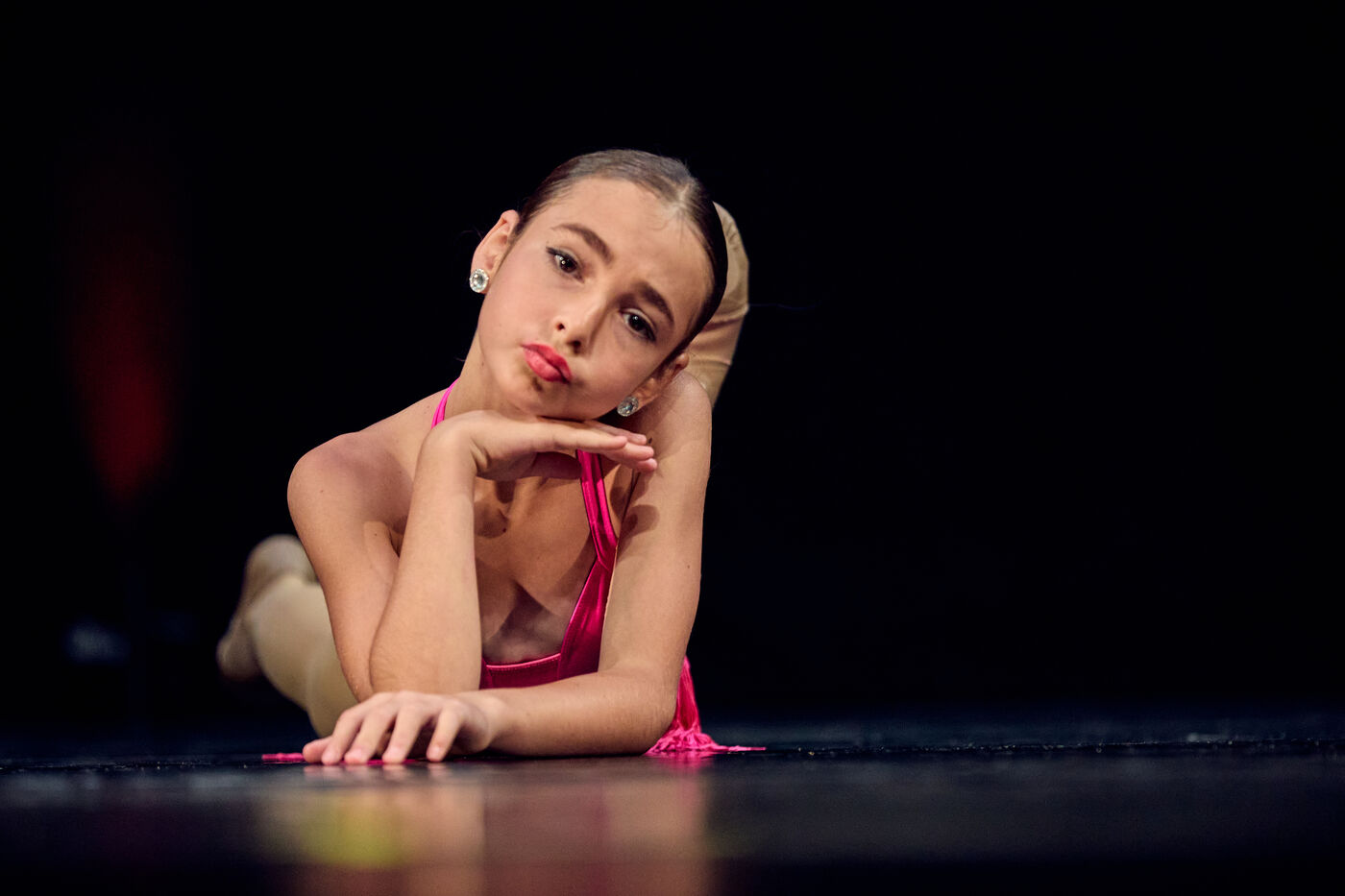 Young AFDS dancer resting her chin on her hands on stage