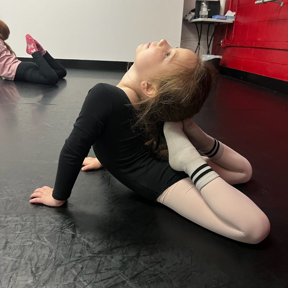 Young dancer in a floor stretch during technique class