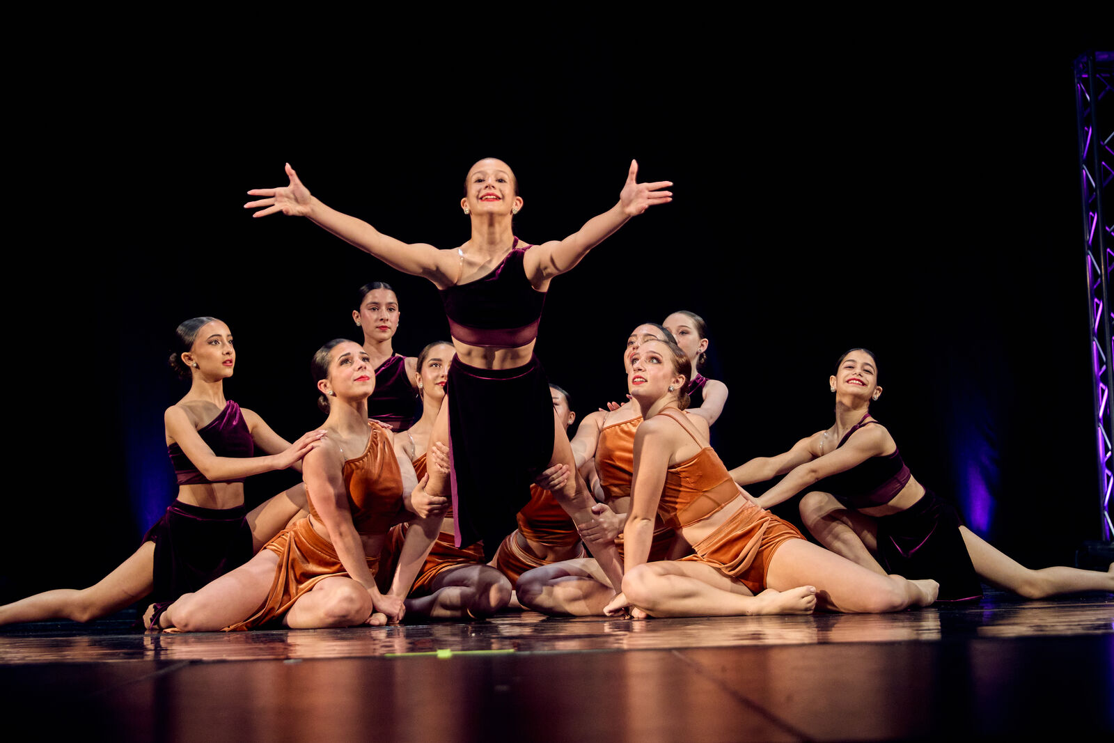 Synergy group routine with a soloist centered, arms open wide