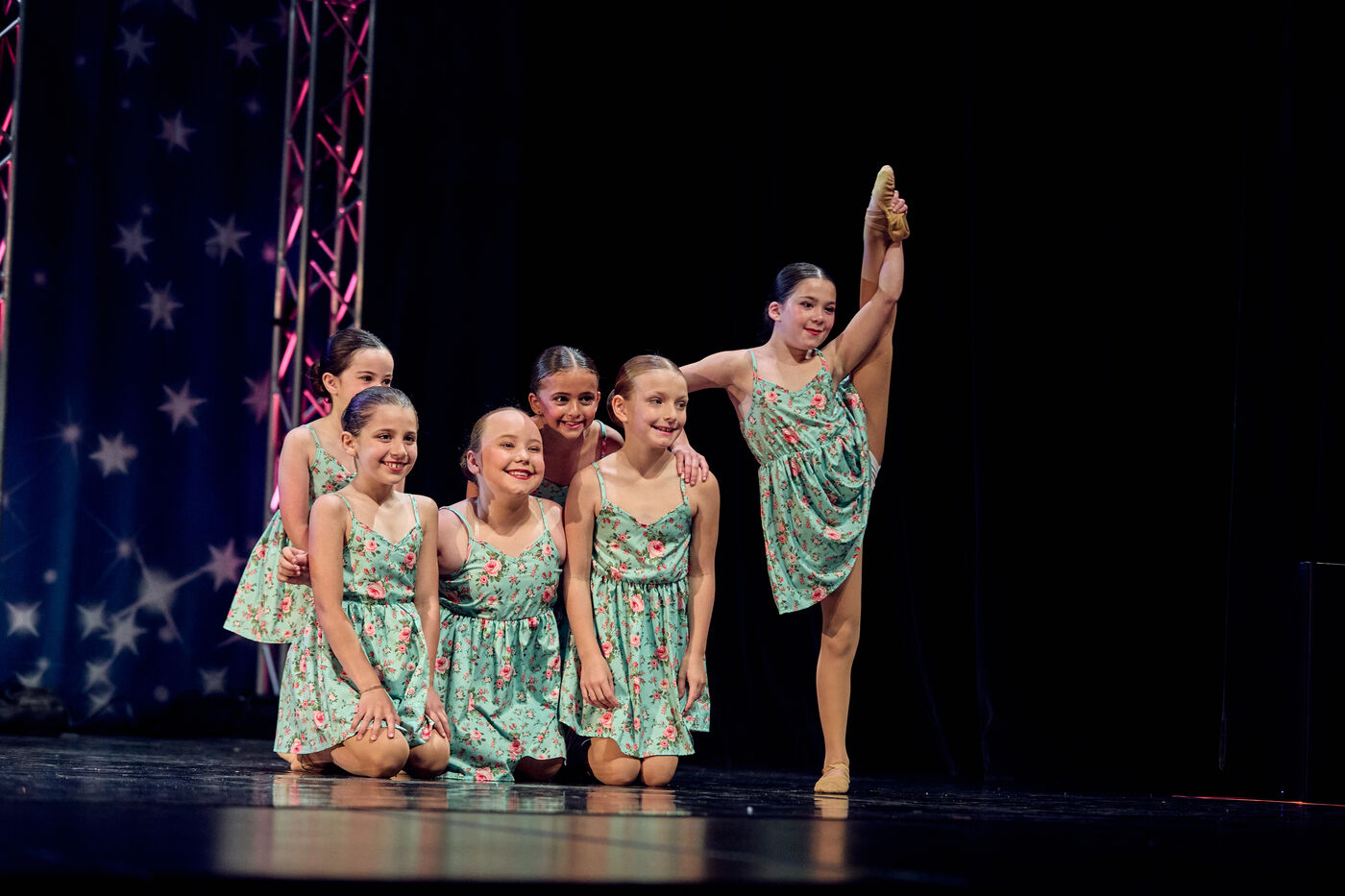 Synergy group routine with a dancer in a high extension