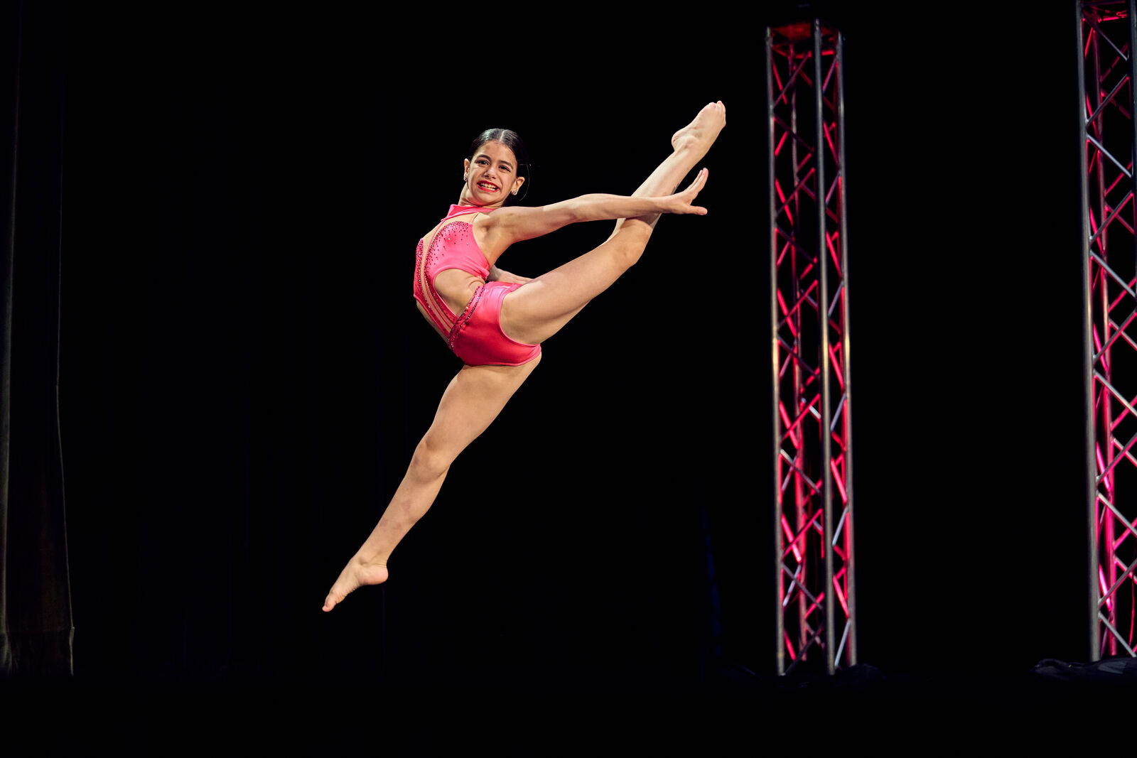 AFDS dancer in a mid-air leap with a full split extension