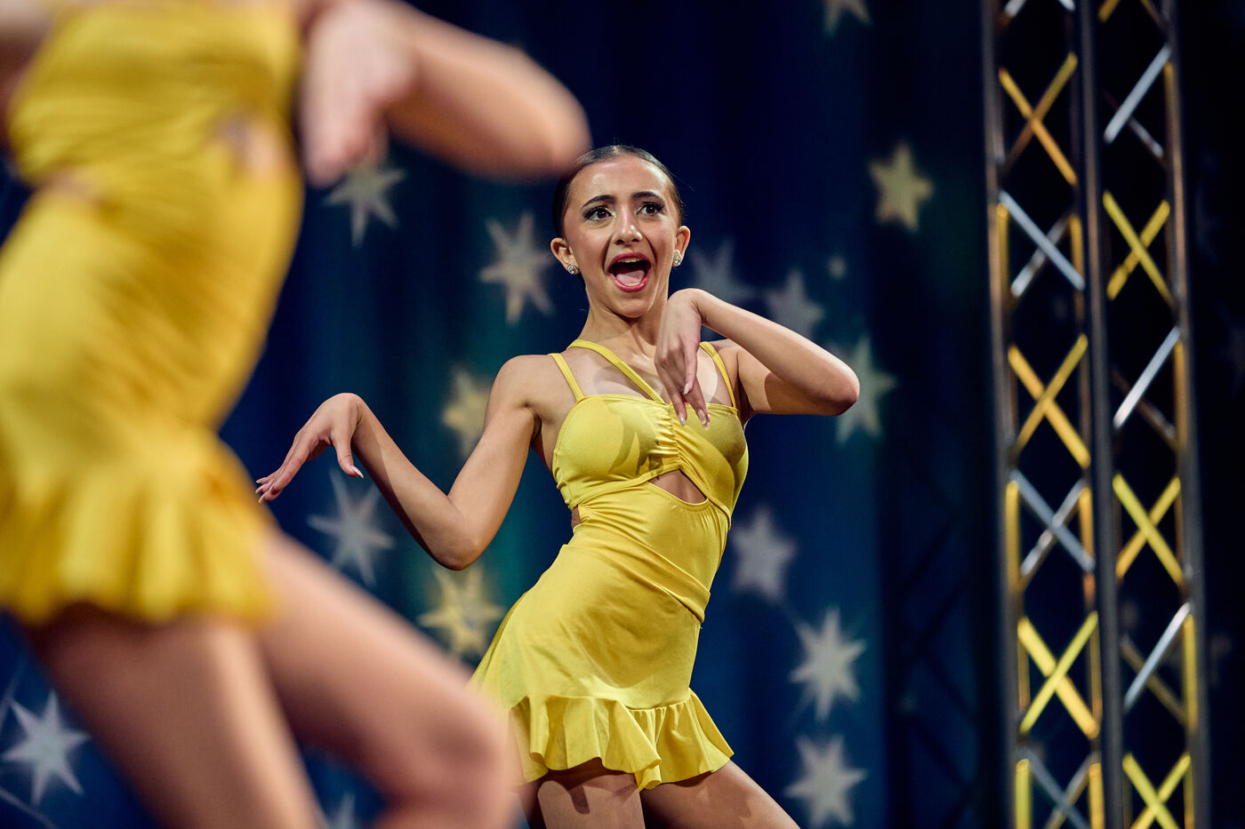 Soloist in a yellow costume performing with big expression