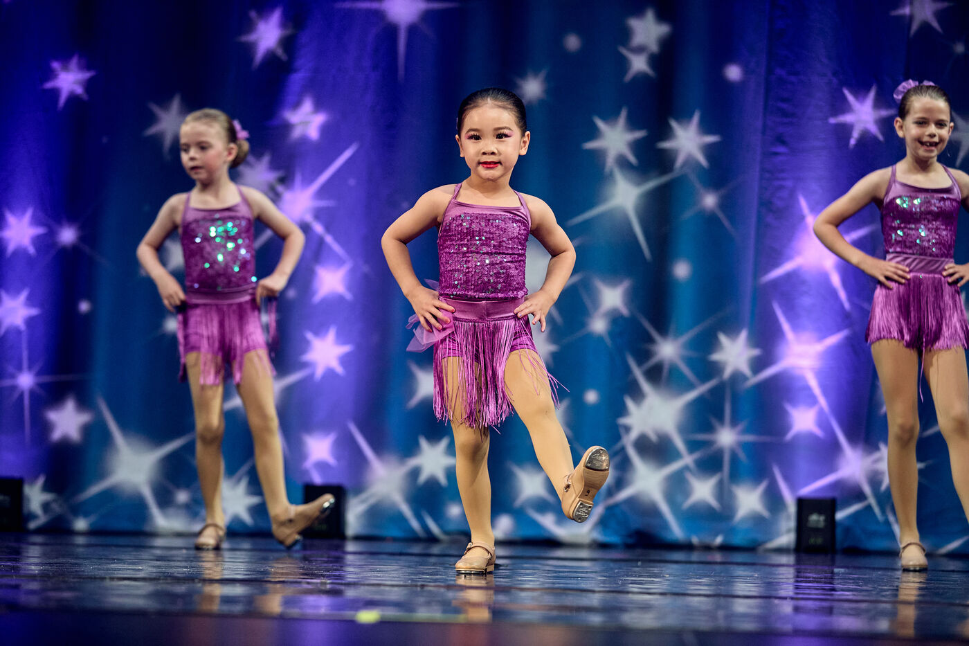 Trio in purple costumes holding a pose together